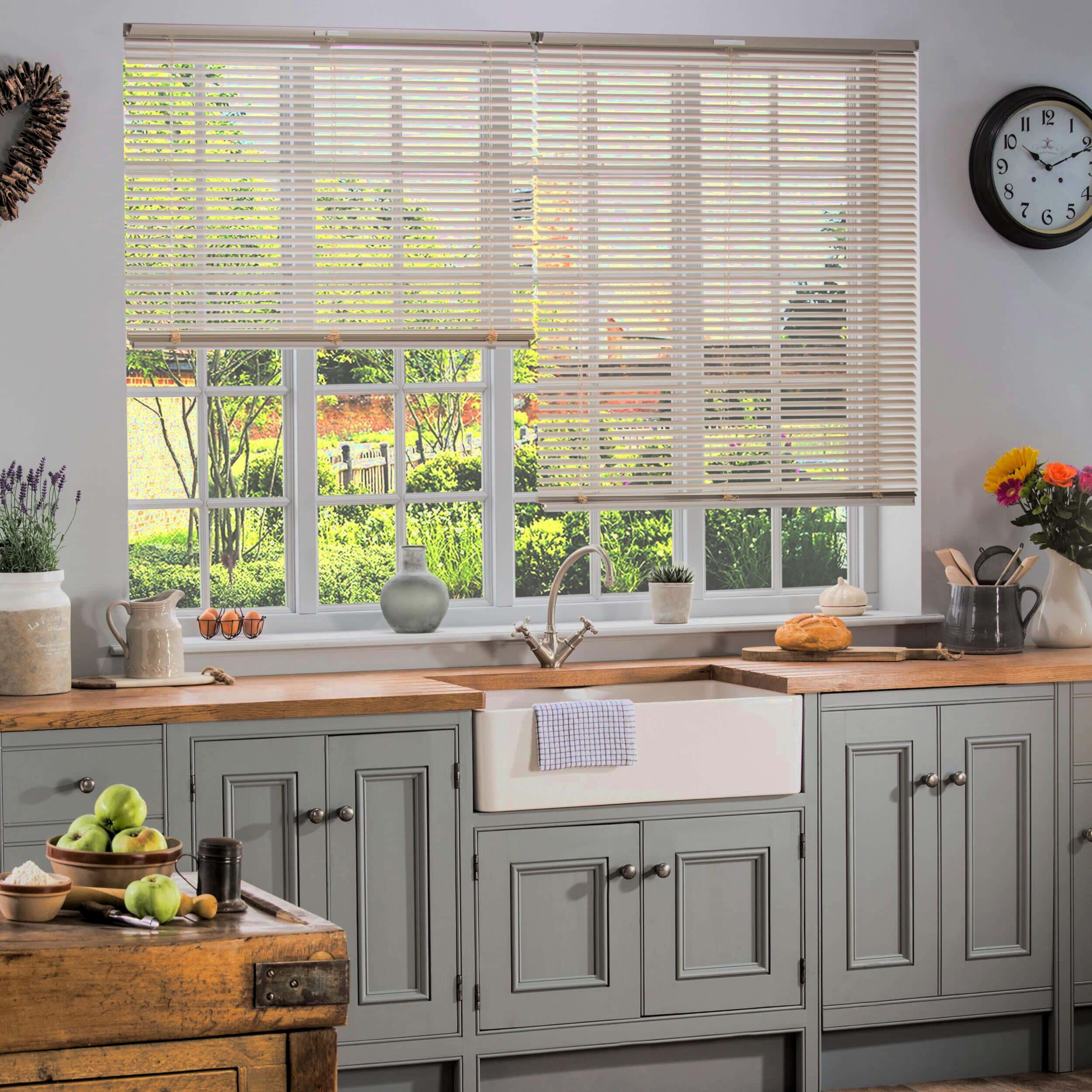 Professional shutter installation in Thundersley featuring horizontal wooden blinds over a farmhouse sink in a sage green kitchen cabinet setting