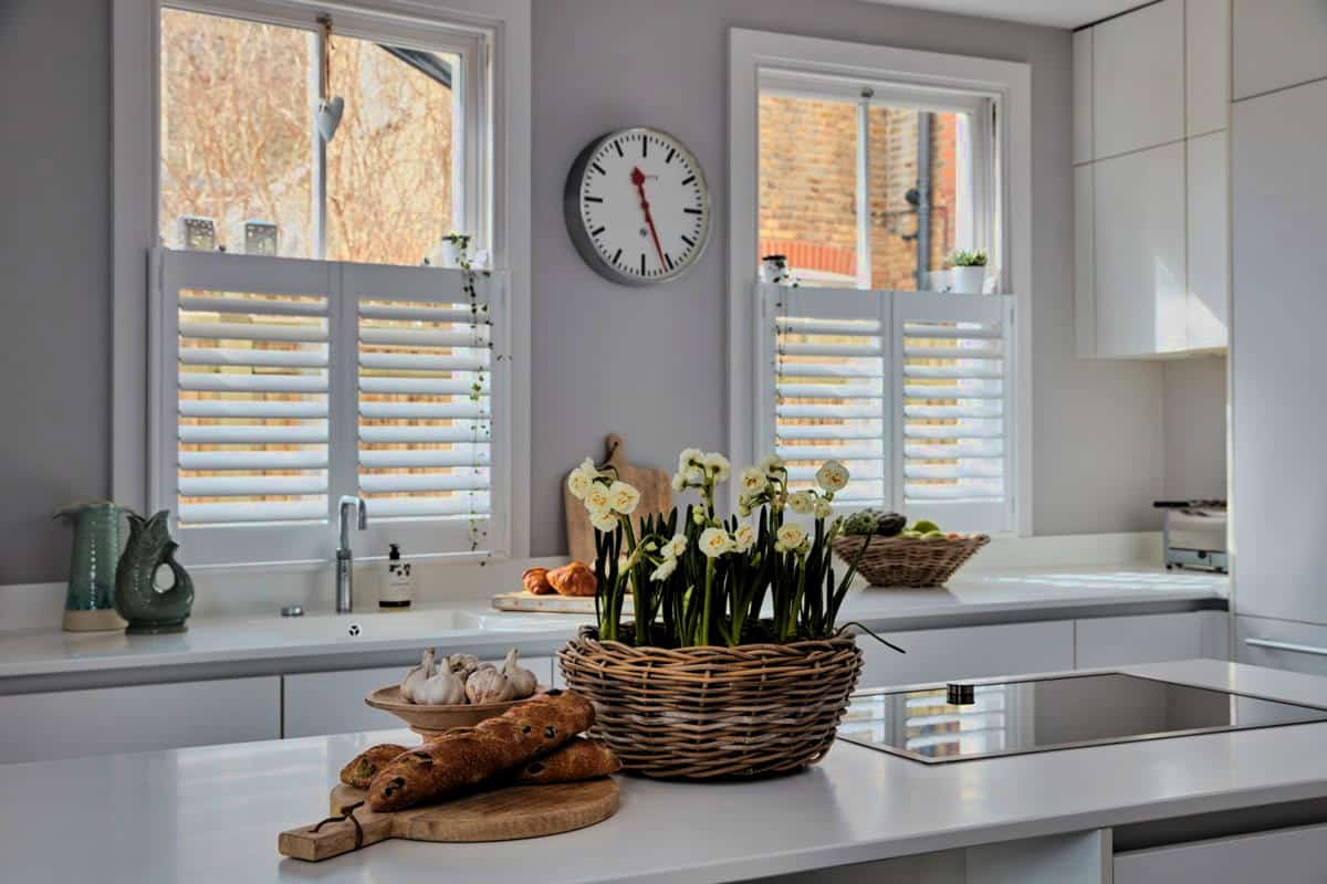 Elegant white fitted window shutters in Fobbing installed in a contemporary kitchen, providing privacy while allowing natural light