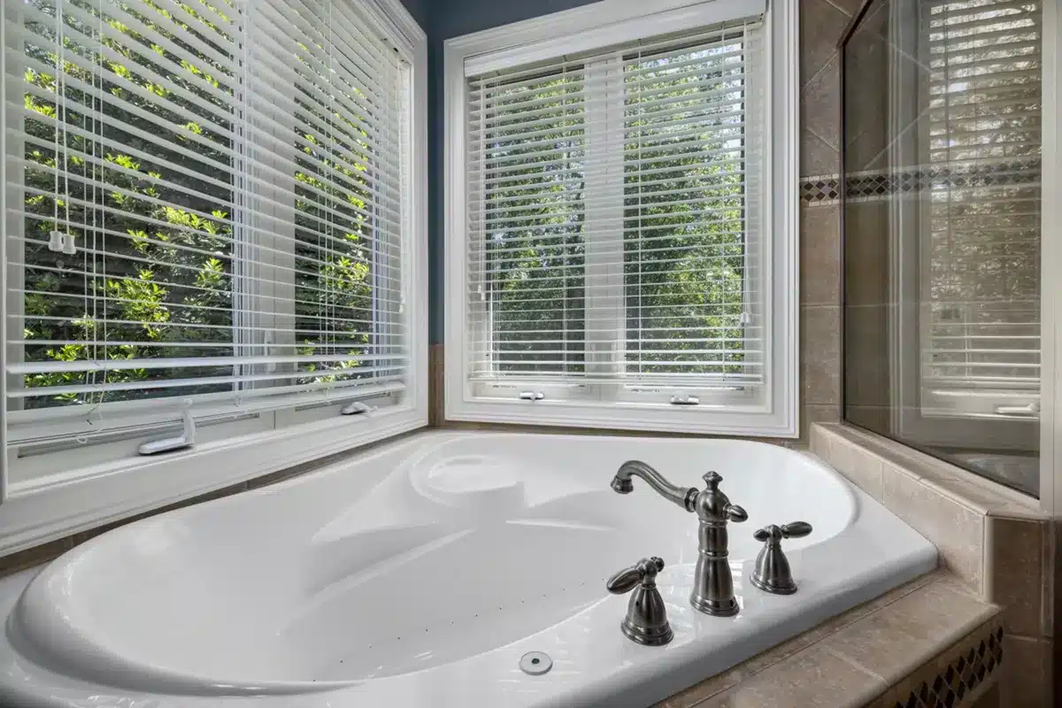 Luxurious bathroom featuring affordable shutter installation cost in stock options from London Essex Shutters and Blinds