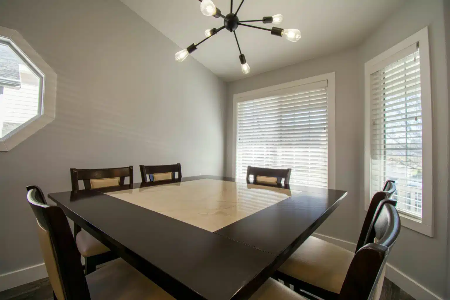 Professional Shutter Installation in Bow featuring elegant white blinds in a contemporary dining room setting