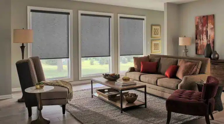 Elegant living room featuring custom shutter installation in Cliffe with three large windows showcasing gray roller blinds by London Essex Shutters and Blinds